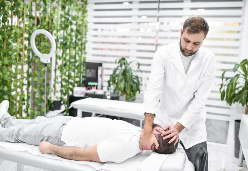 A patient is getting treatment for neck pain from Dr. Salvatore Palumbo on Long Island